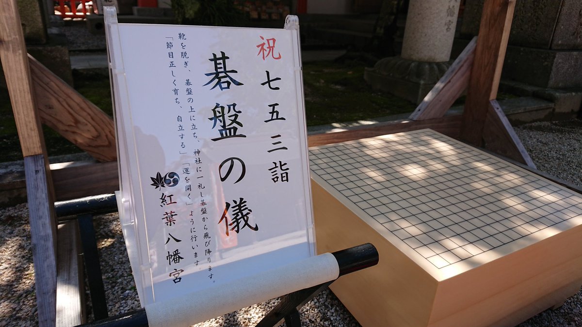 「祝七五三詣 碁盤の儀」と書いた札と、木の碁盤